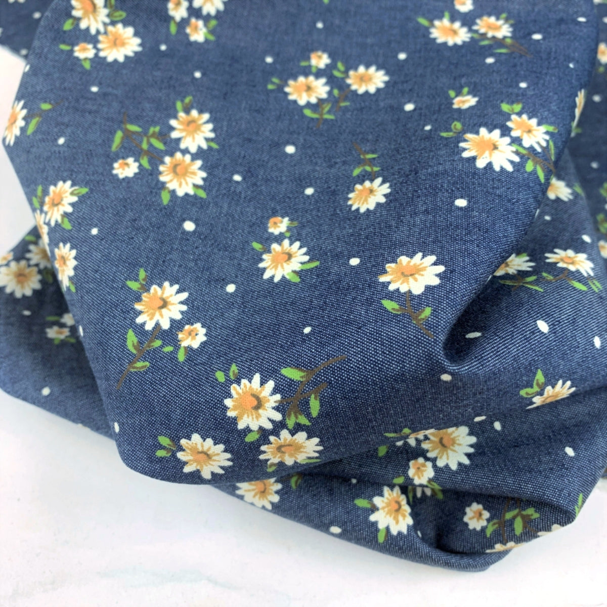 Heavenly evening daisy lightweight multicoloured cotton printed denim chambray shirting fabric roll close up fabric photo